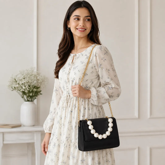 Luxury black structured crossbody bag with pearl handle, gold chain strap, and premium PU leather for women.